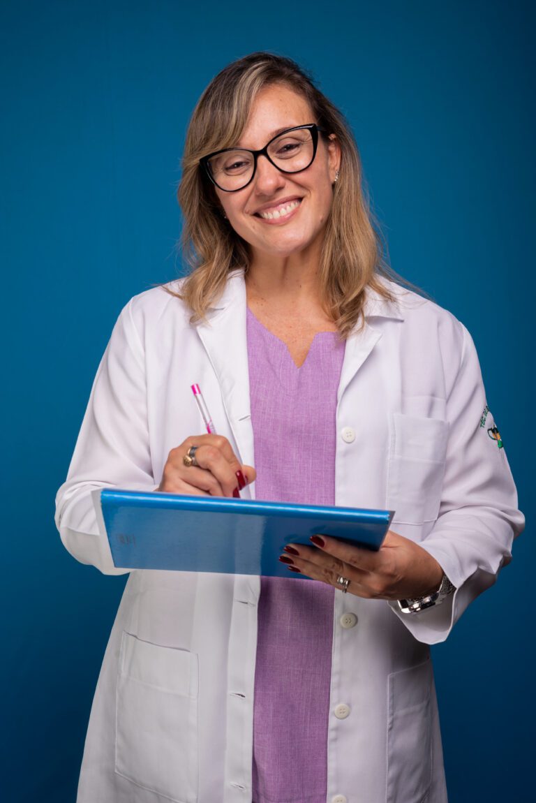 Confident nurse in a white coat and lilac blouse, wearing glasses, writing on a paper in a calm and professional setting.