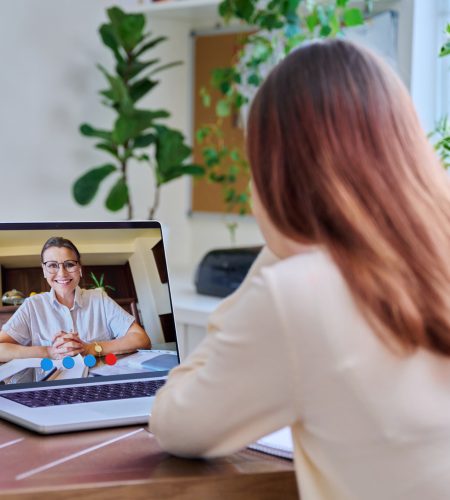 Young woman in a virtual therapy session with a psychologist, engaging in an online therapeutic conversation from home